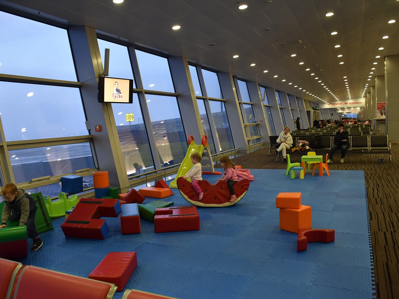 Children playing in a family play area inside an airport terminal